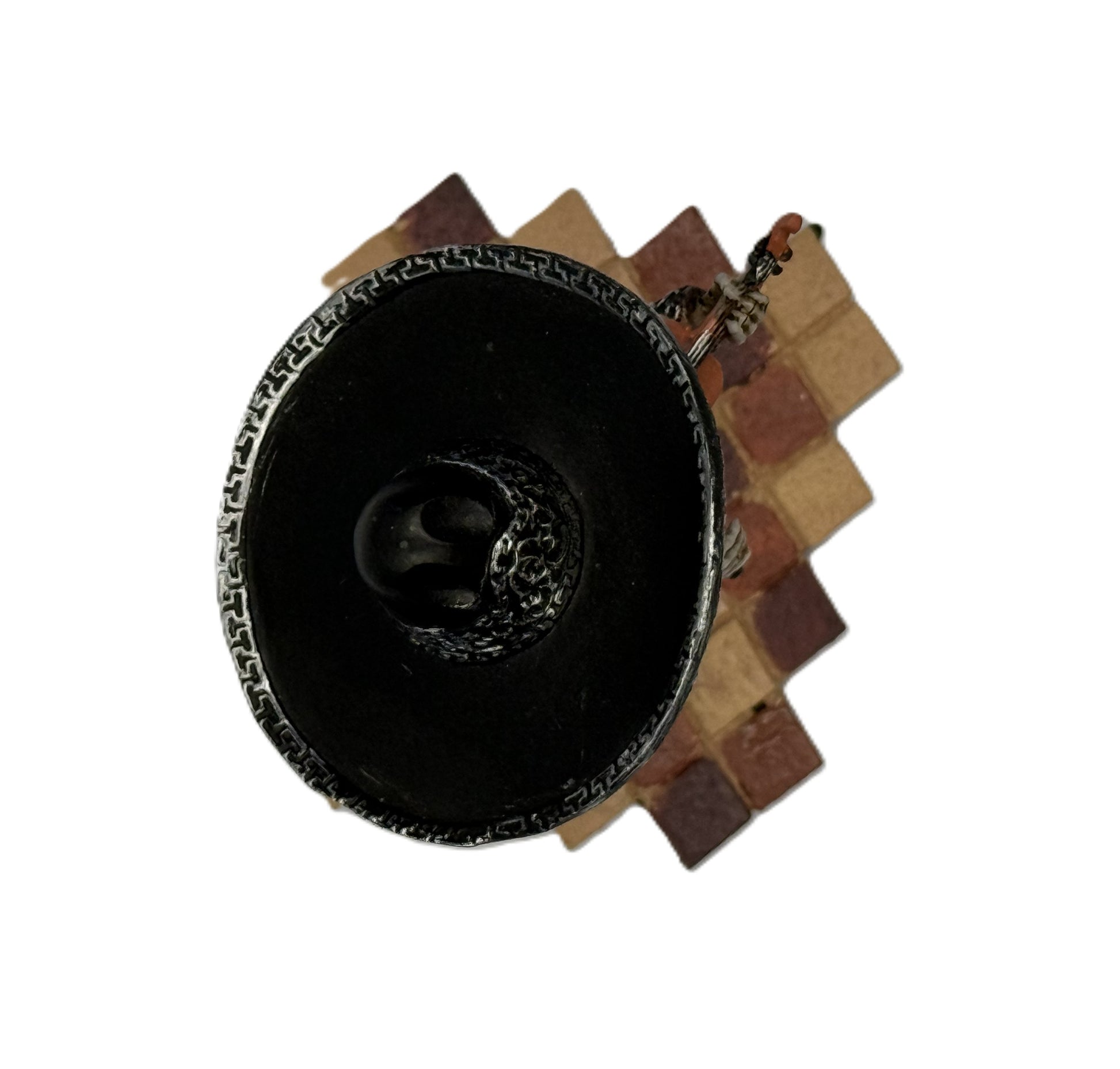 Top view of mariachi skeleton figurine showing sombrero and tiled base pattern
