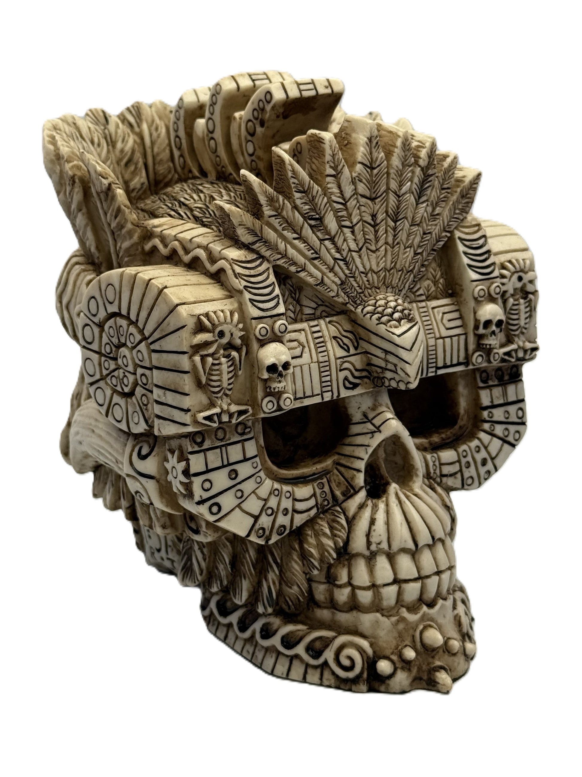Angled view of Montezuma skull decor with layered feather crown and hand painted resin texture
