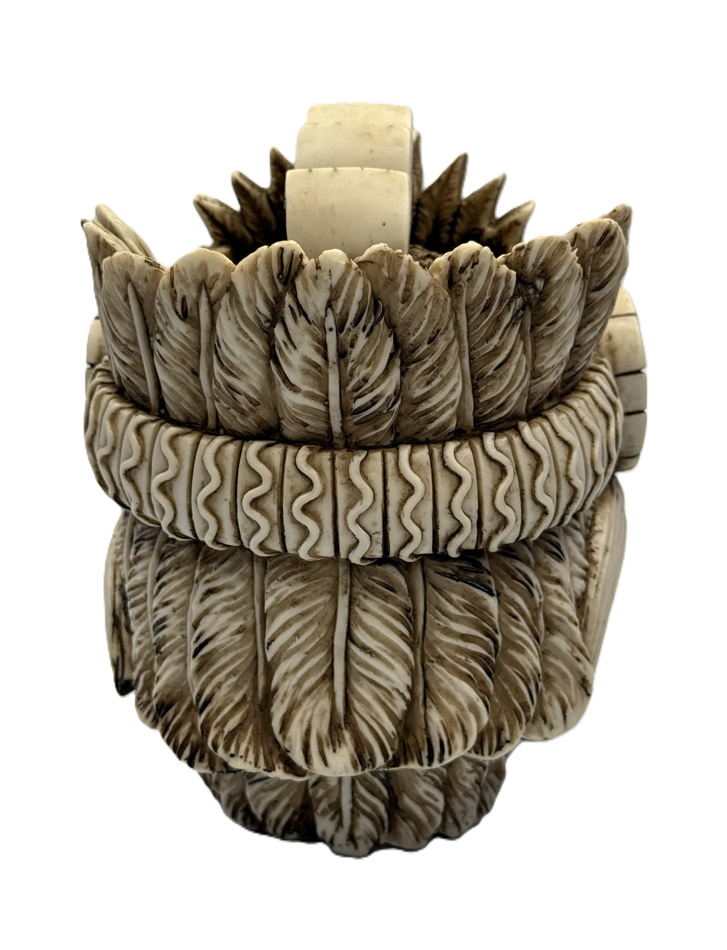 Back view of Montezuma skull statue showing layered feather design and carved band details
