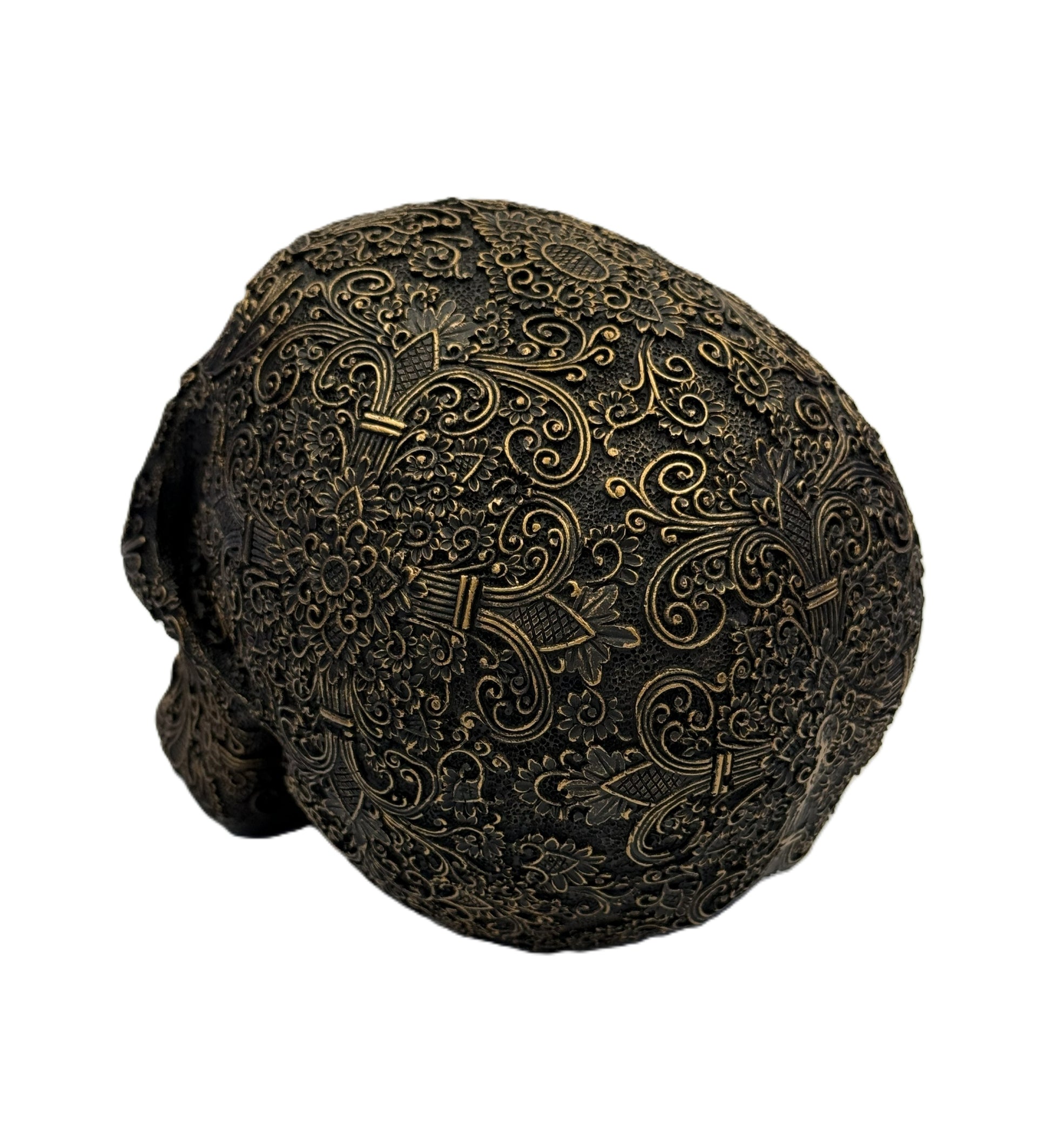 Back angled view of skull sculpture featuring symmetrical floral engravings and vintage bronze coloring
