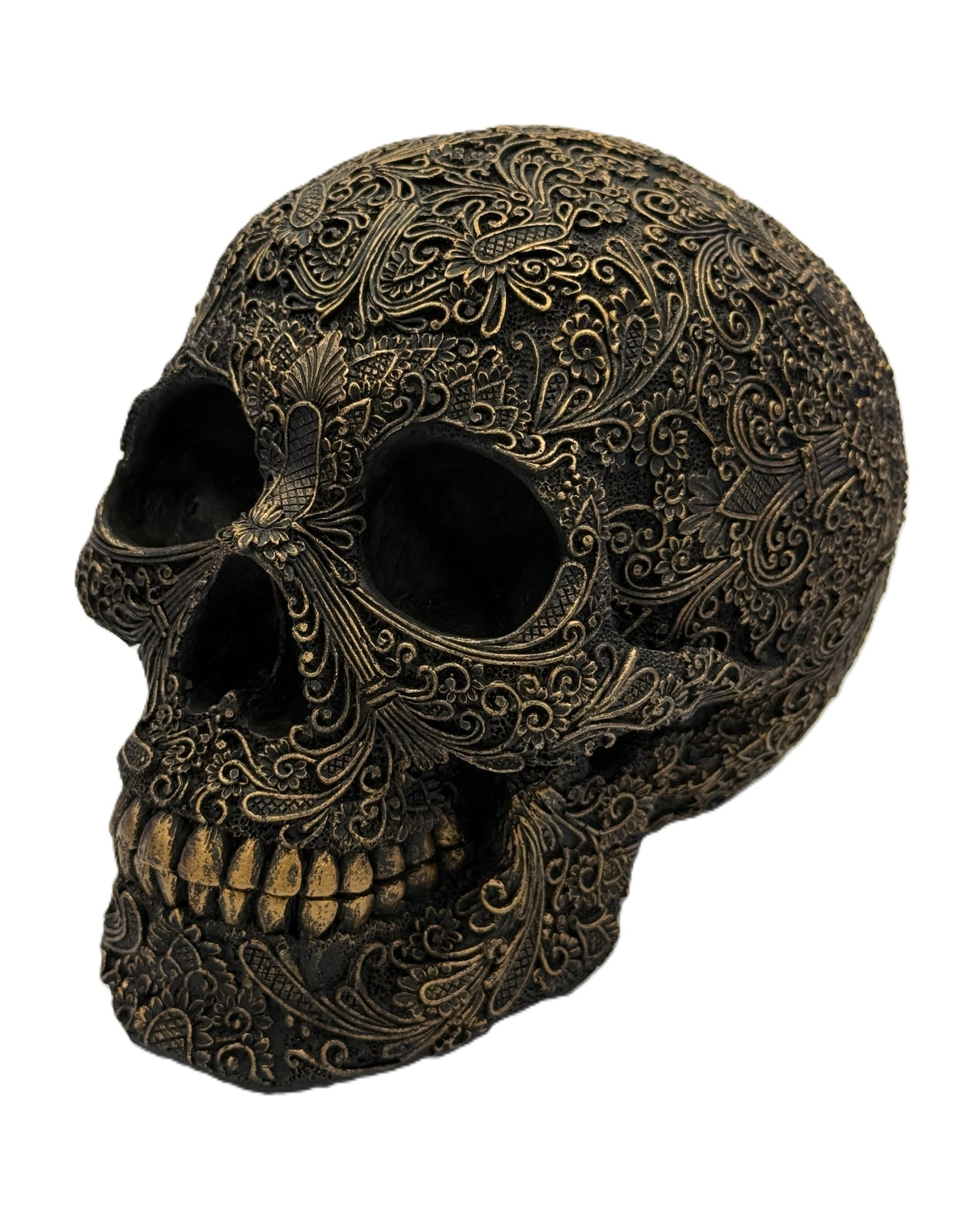 Front angled view of ornate carved gothic skull sculpture with intricate floral patterns and antique bronze finish
