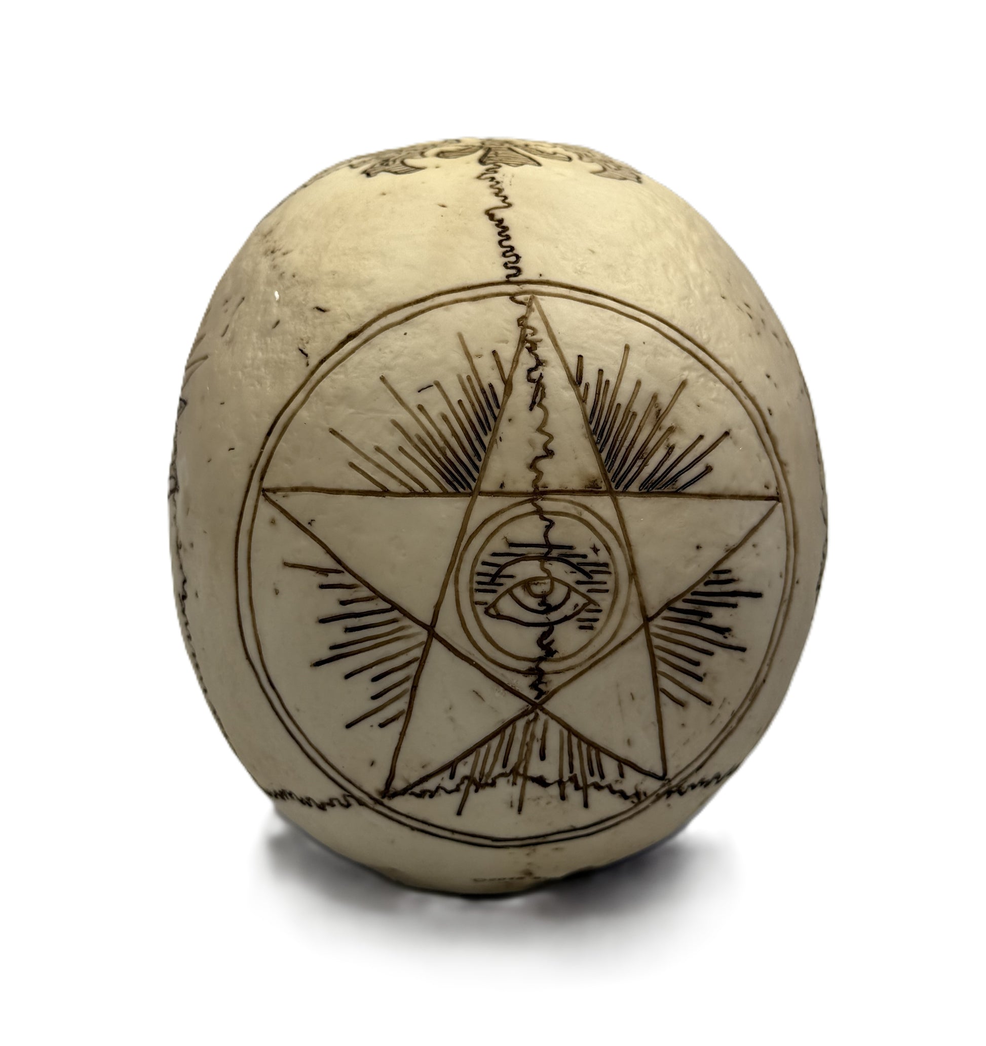 Back view of skull statue showing pentagram with all seeing eye and radiant line engravings
