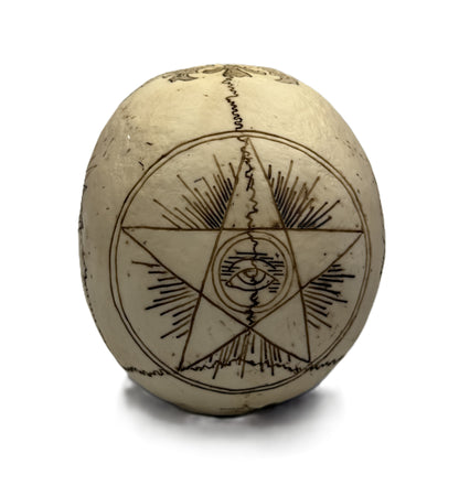 Back view of skull statue showing pentagram with all seeing eye and radiant line engravings
