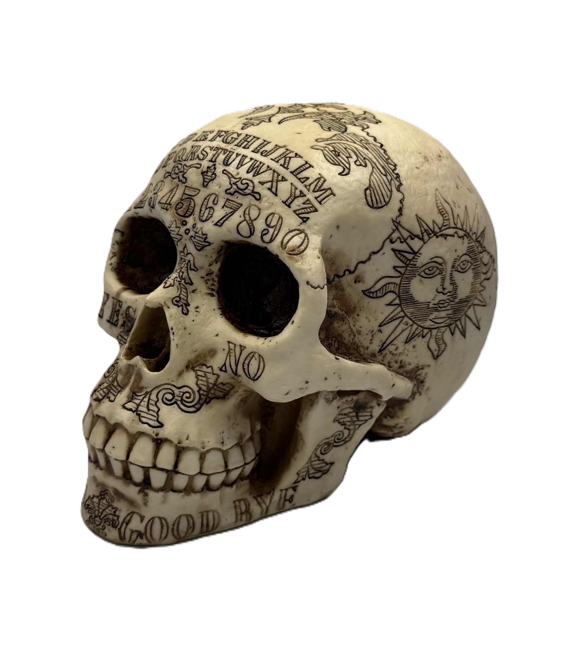 Front angled view of Ouija skull statue with engraved alphabet, numbers, and gothic occult details

