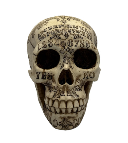 Straight front view showing Ouija alphabet engraving and detailed skull features
