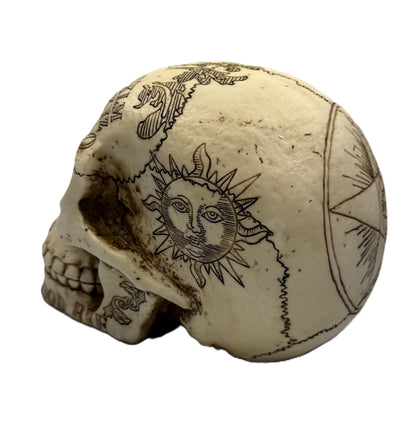 Side view of gothic skull decor featuring engraved sun face and weathered bone finish
