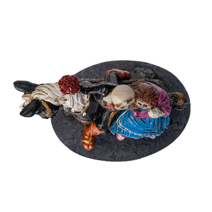 Top view of skeleton couple figurine on horse with bouquet
