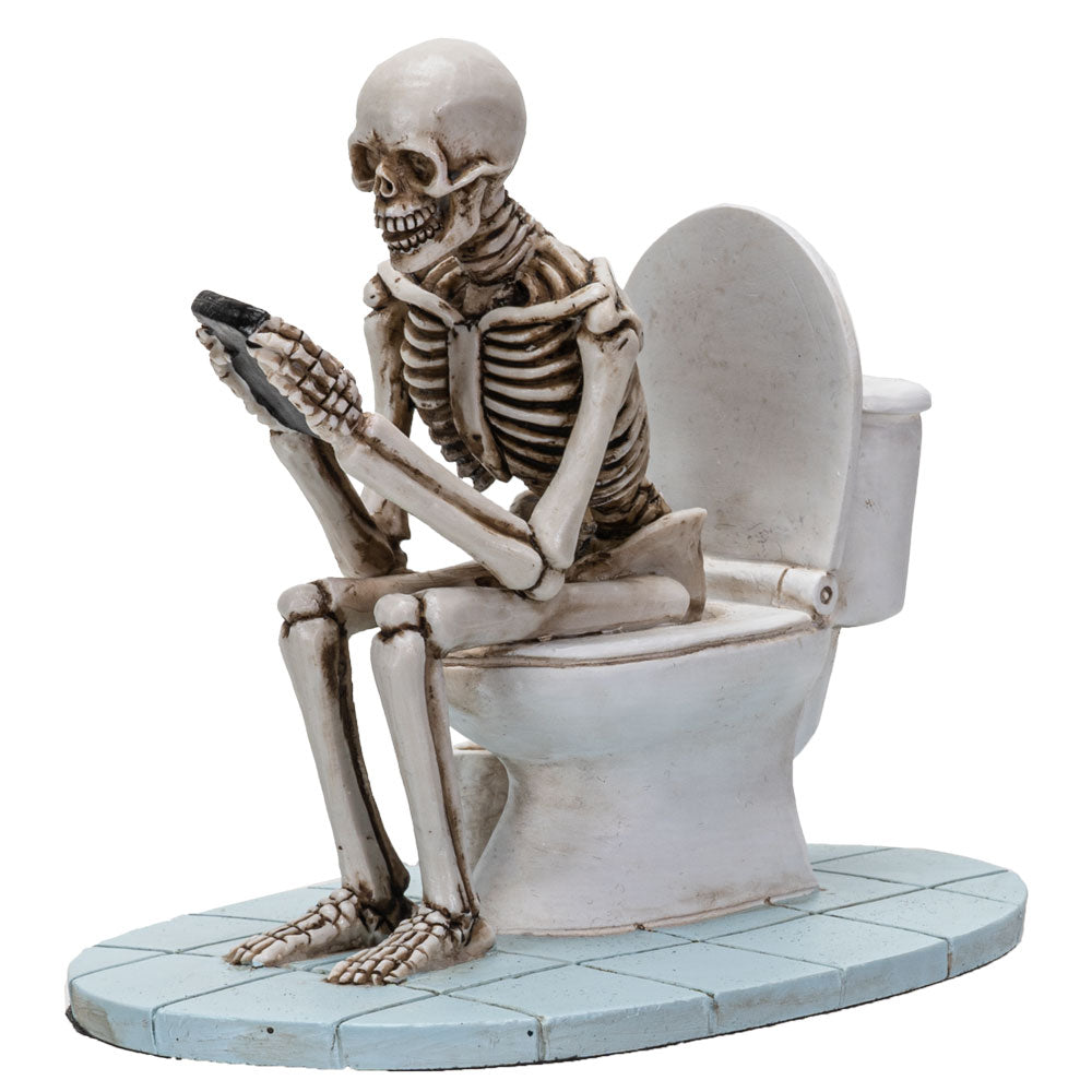 Front angled view of skeleton sitting on toilet reading with detailed sculpting and hand-painted finish
