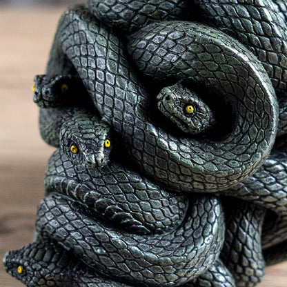 Close-up of snake skull decor showing detailed scales and yellow serpent eyes
