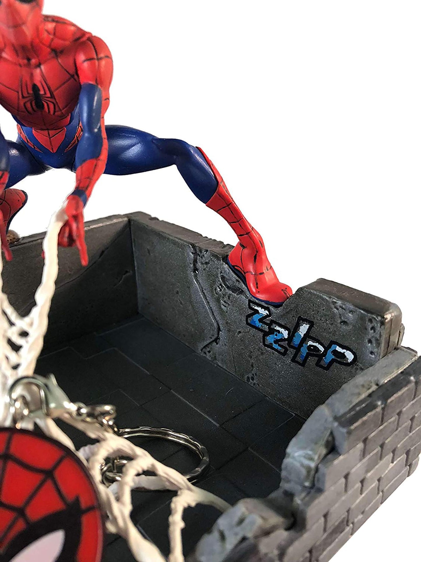 Spider-Man statue showing web action and comic style zip text detail
