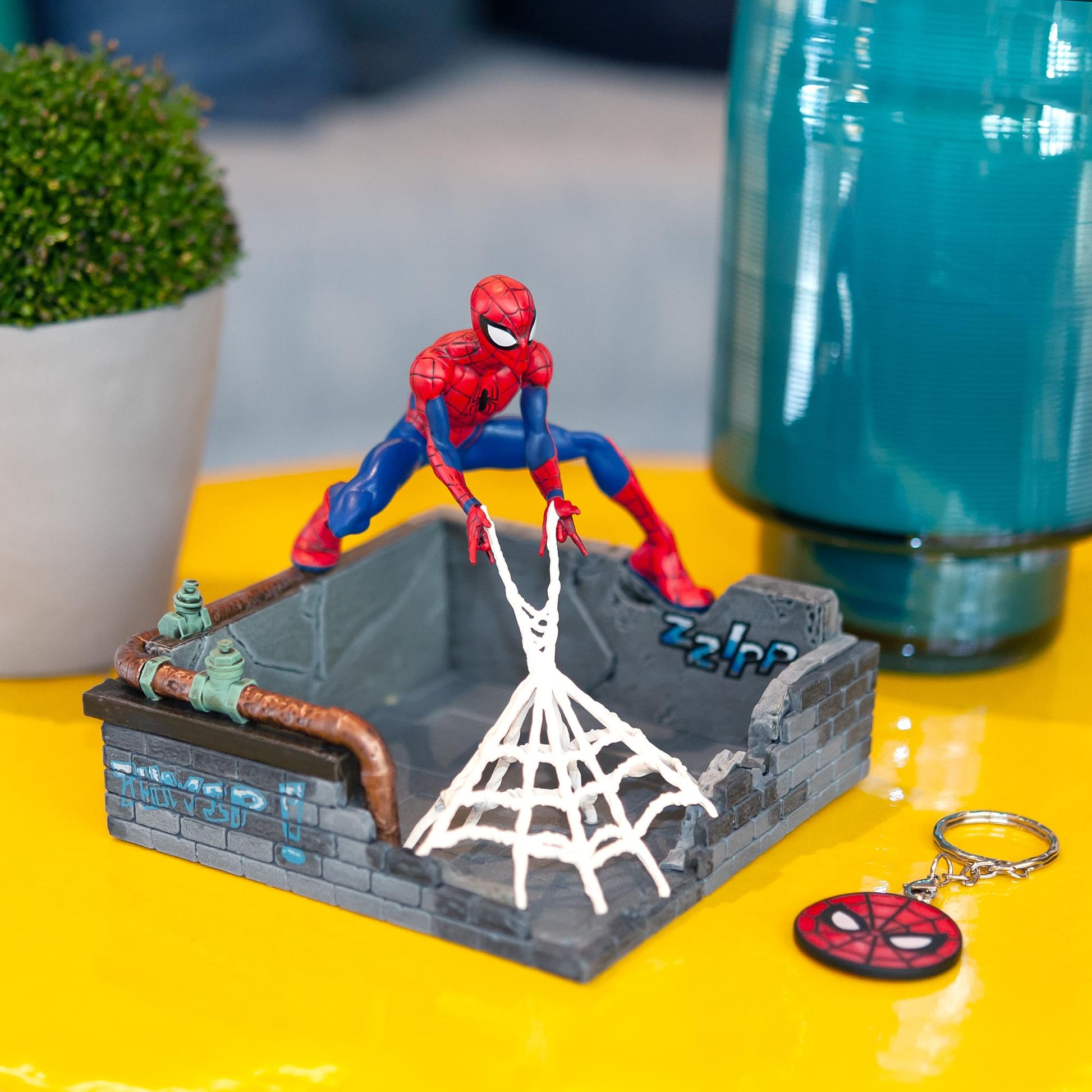 Spider-Man key holder statue on desk holding keys and everyday items
