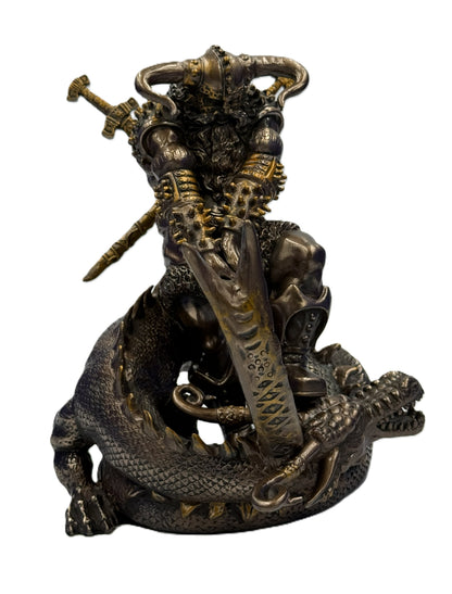 Close front view of Thor statue with spiked armor, horned helmet, and dragon beneath in detailed bronze collectible
