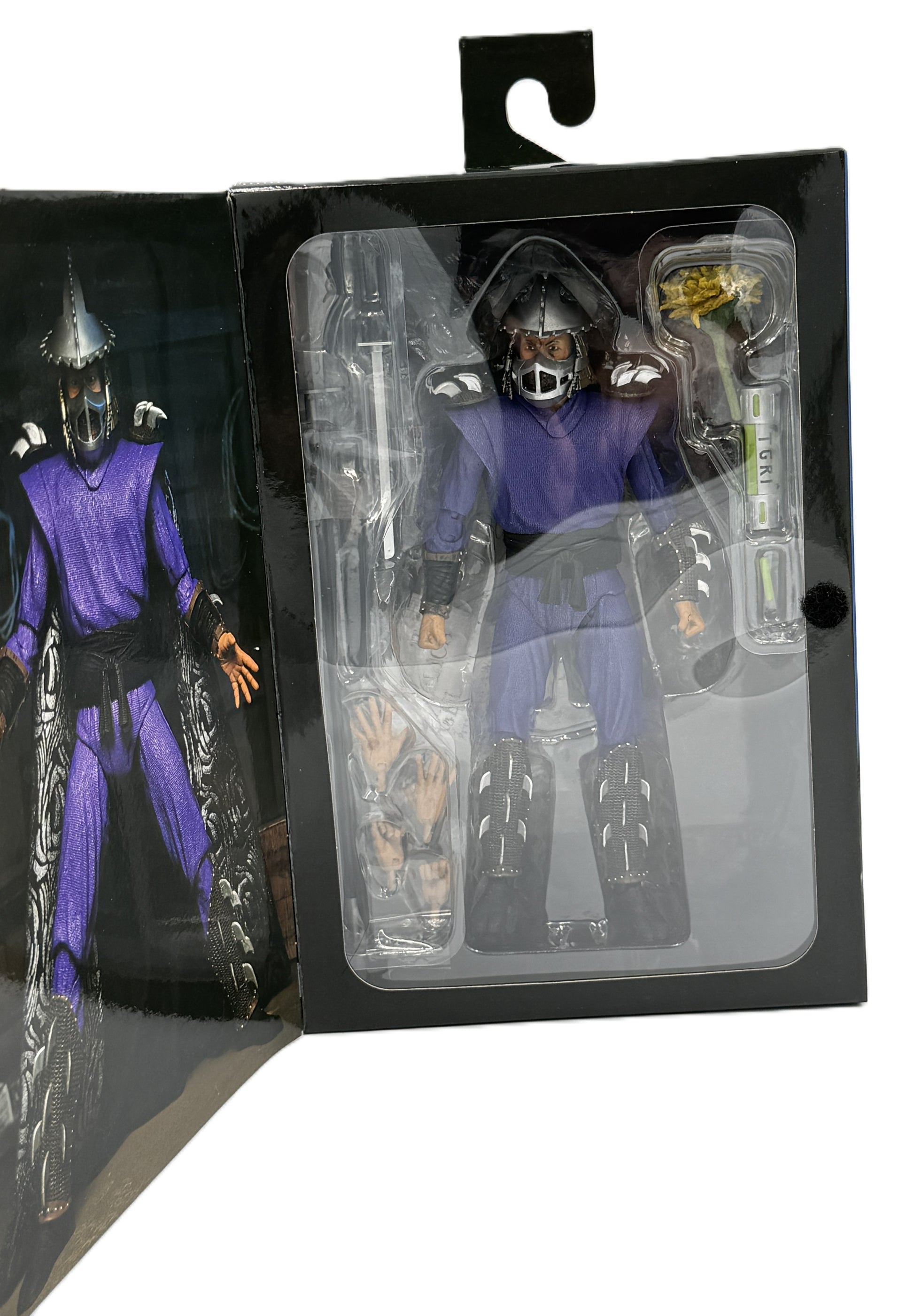 Close-up of the NECA Ultimate Shredder action figure and accessories inside the display packaging.