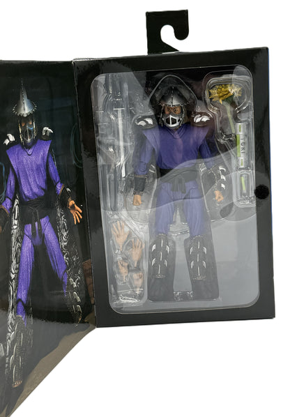 Close-up of the NECA Ultimate Shredder action figure and accessories inside the display packaging.