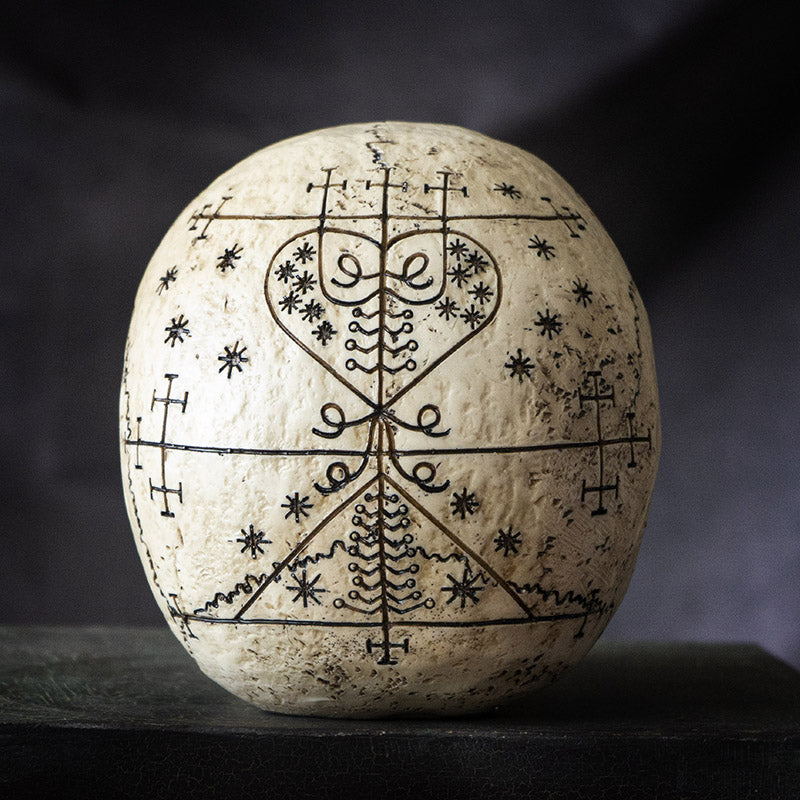 Rear detail of voodoo skull with symmetrical occult symbol patterns
