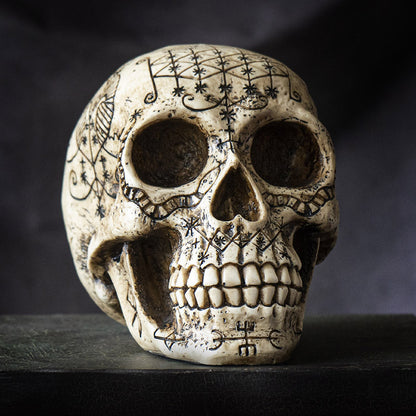 Angled front view of voodoo skull showing detailed carvings and textured surface
