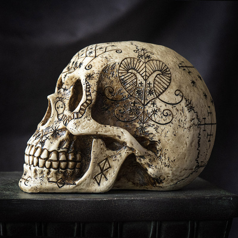 Right side view of voodoo skull statue highlighting symbolic engravings and texture
